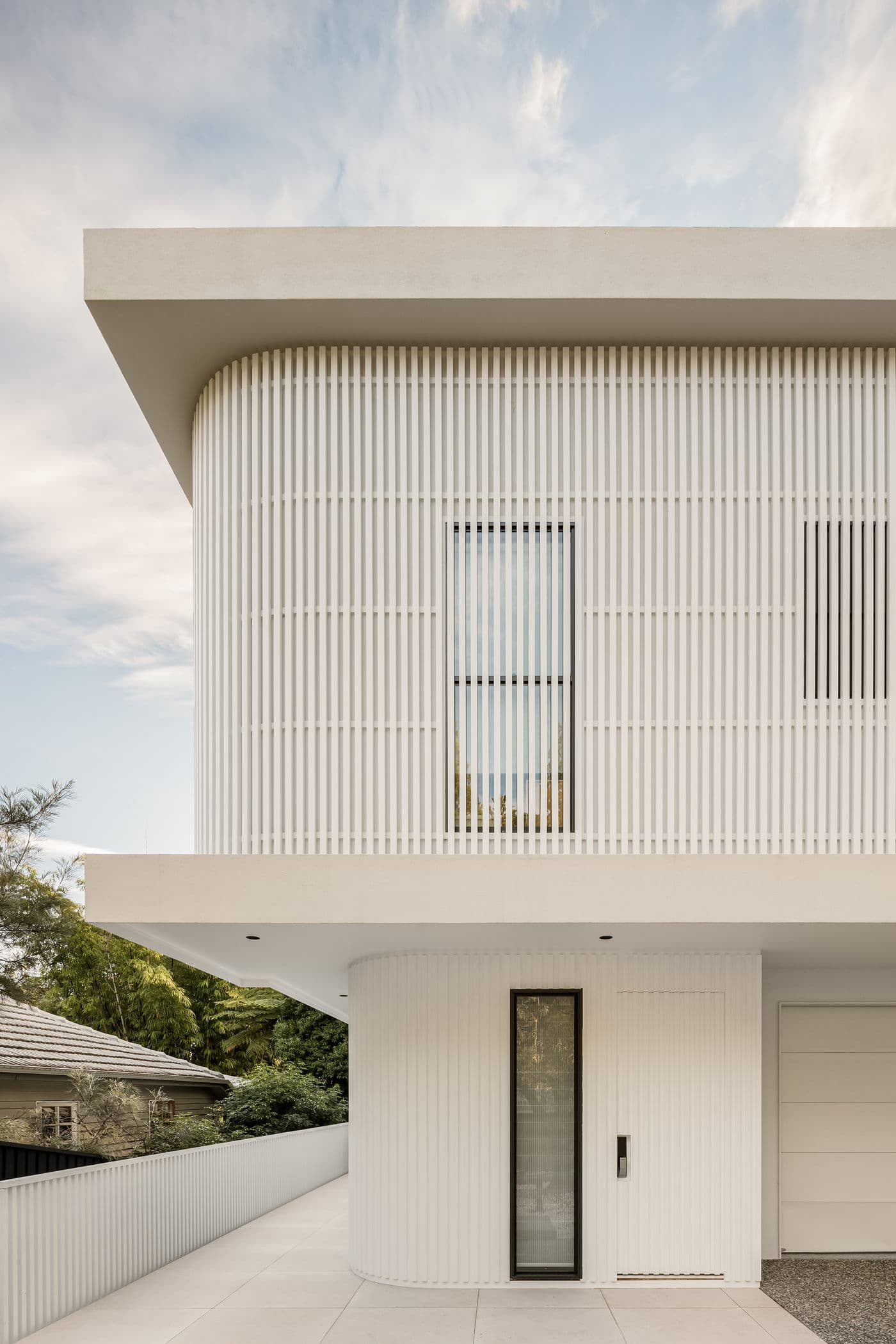 Battened white facade and curved corner at 55 Orchard Terrace