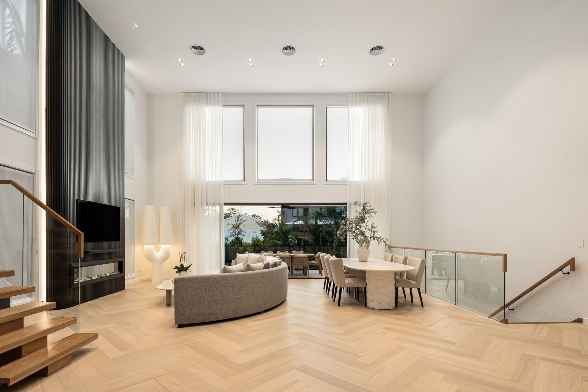 Double-height living and dining opening to the terrace