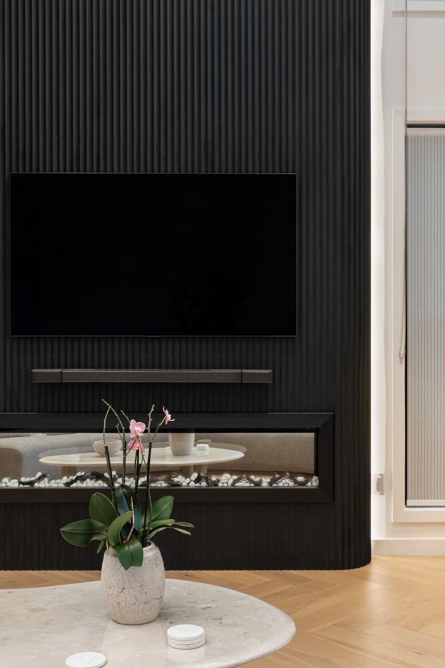 Fluted black joinery and linear fireplace detail