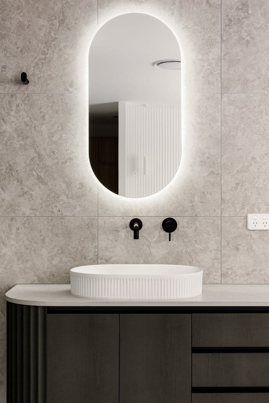 Ensuite with arched backlit mirror and stone